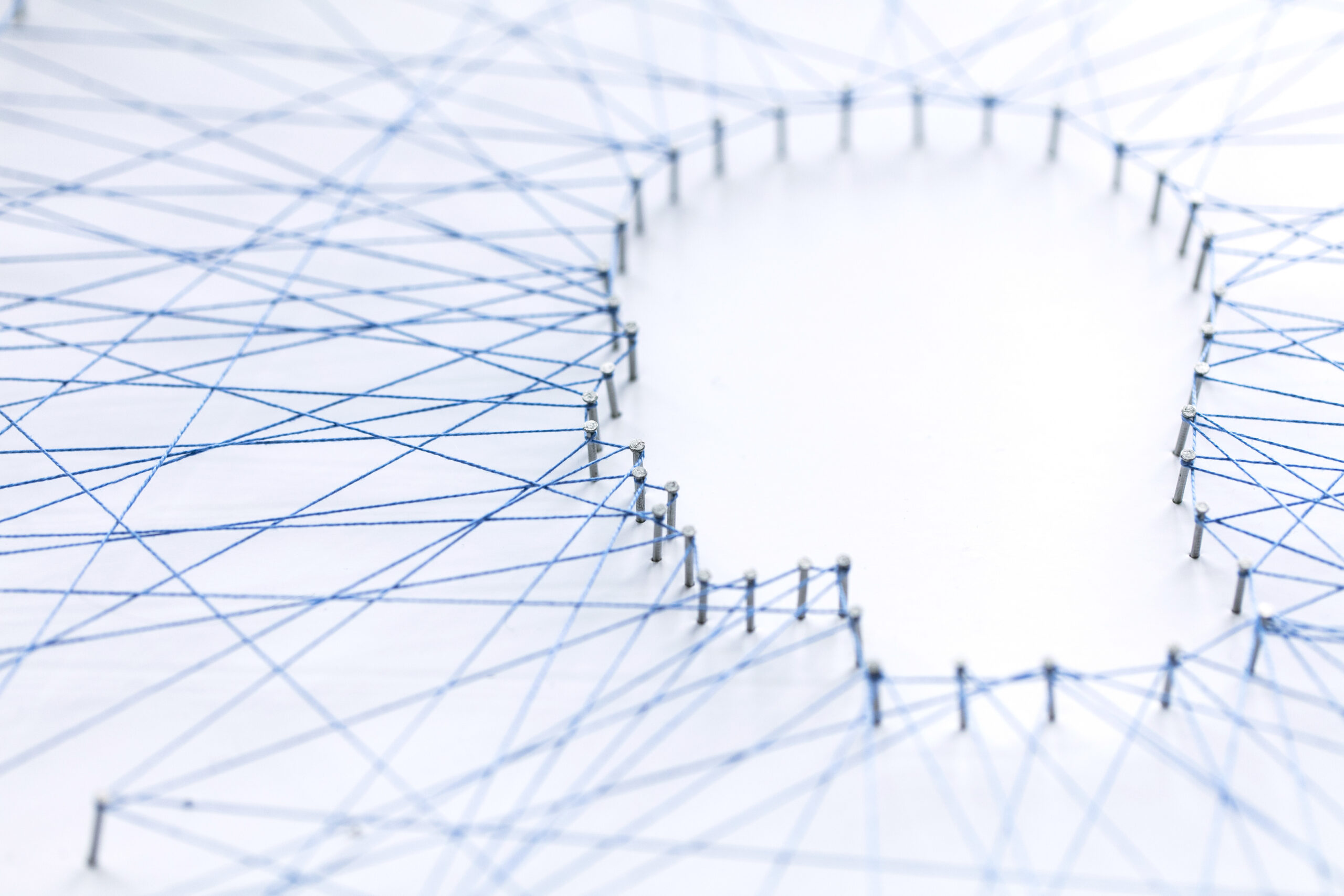 Human head shape made from a large grid of pins connected with string. Communication technology and mental health concept