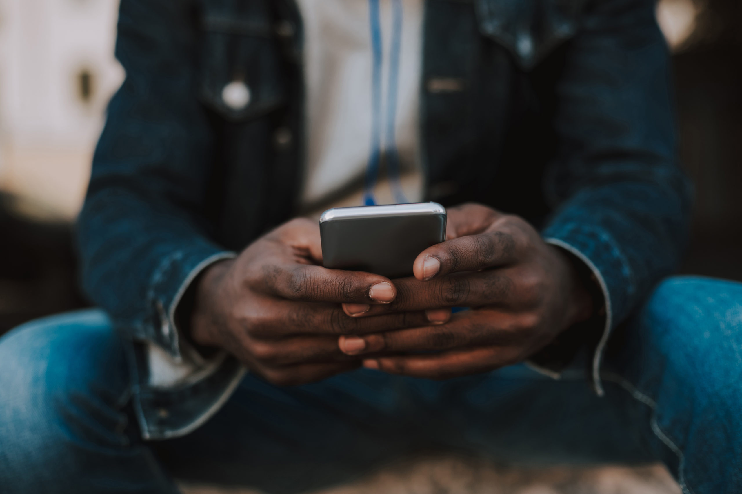 Close up of a smartphone in hands of amro american man